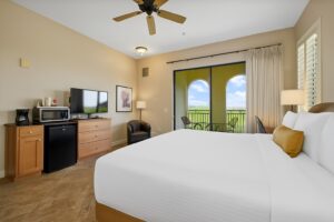 hotel room with king bed, furniture and appliances