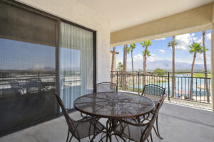 Hotel balcony with sliding door, black metal table, and chairs