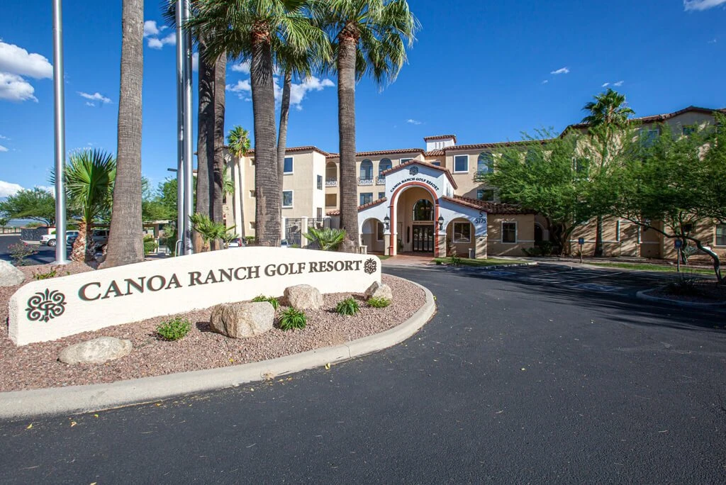 Affordable hotels near Tucson, Canoa Ranch Golf Resort entrance with palm trees and sign