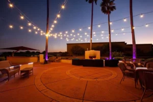 Outdoor space with outdoor kitchen, chair, tables and sofa near fire place
